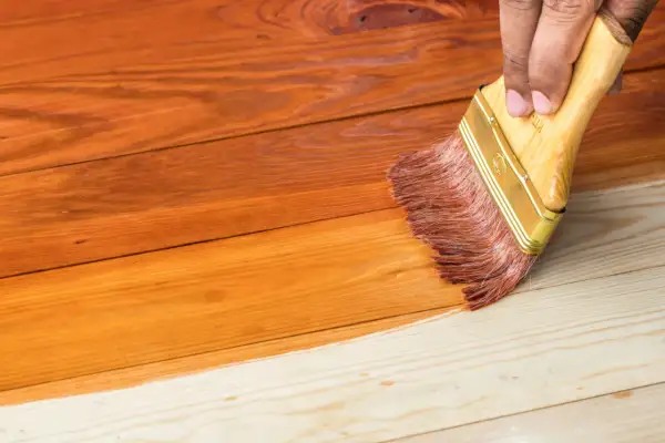 Aplicando barniz a madera de pino sin tratar, transformando su tono natural a un cálido color miel.